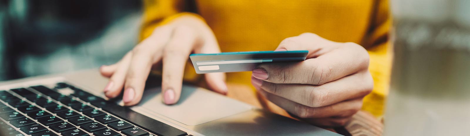 PErson using their debit card to shop online.