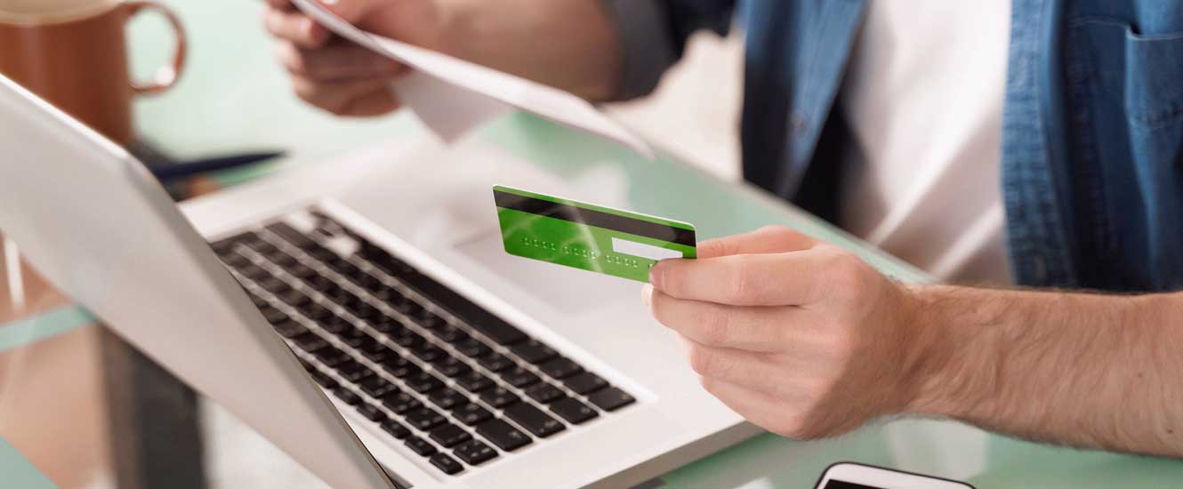 Person holding credit card checking financial statement.