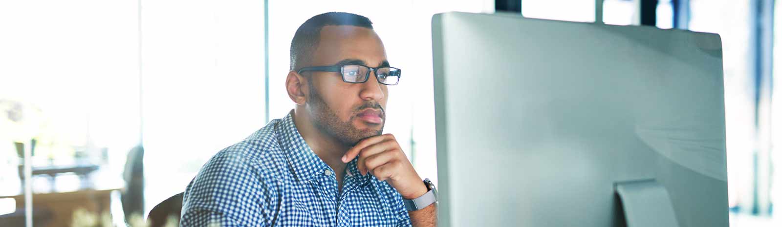 Business person looking at computer monitor.